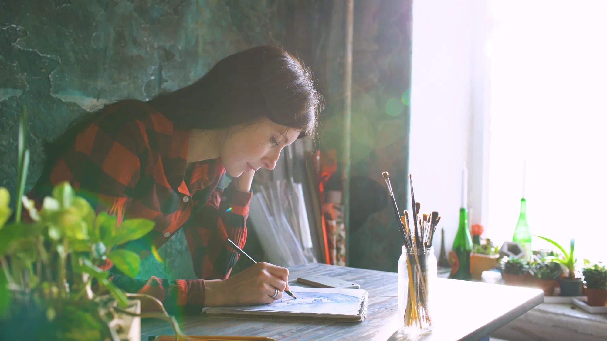 Artist drawing at a sunlit table